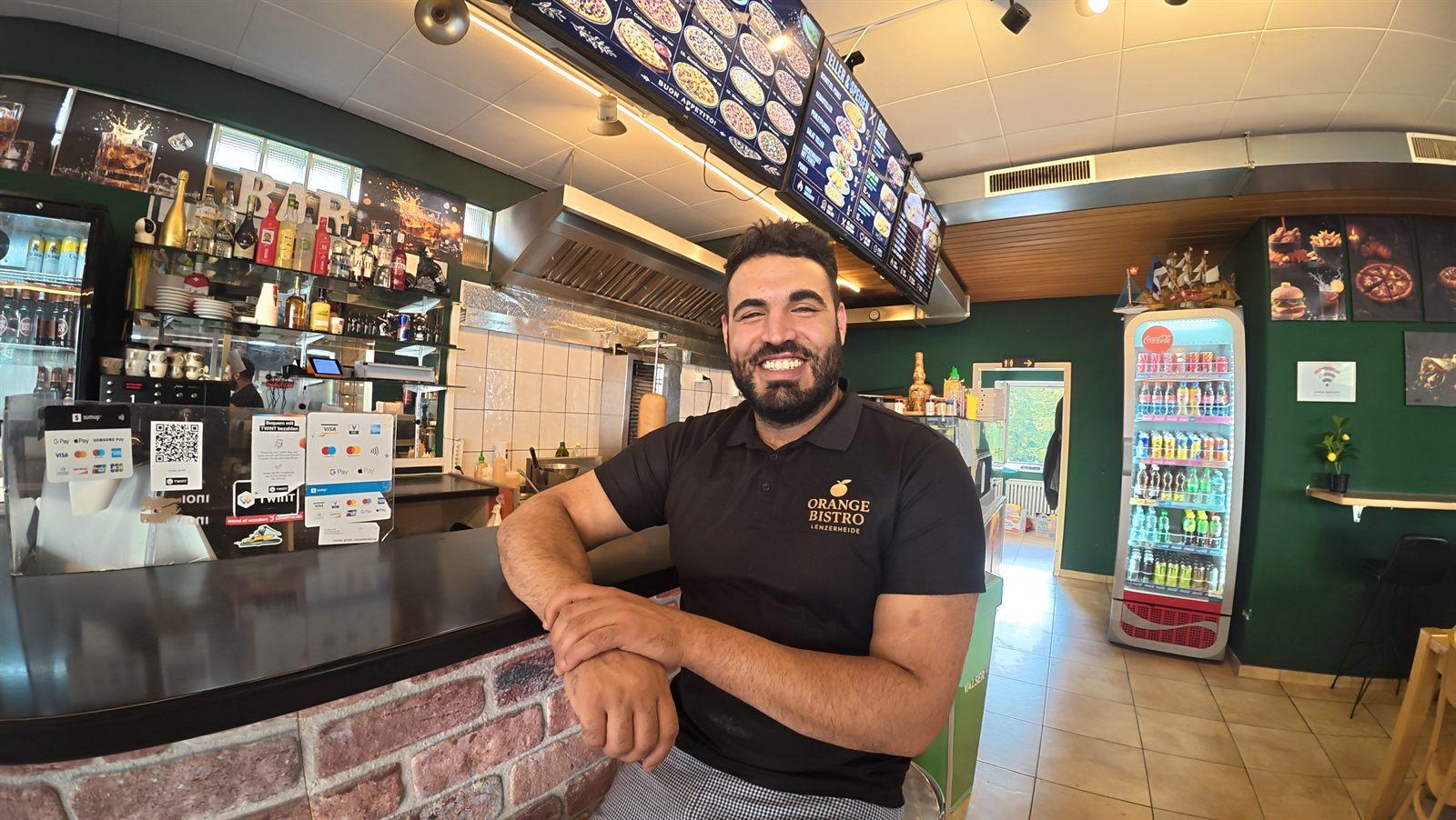 Der Inhaber des Orange Bistro an der Theke